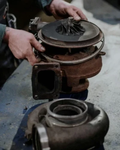 Técnico perito inspeccionando la turbina de un turbo averiado para un informe de vicios ocultos en 2026.